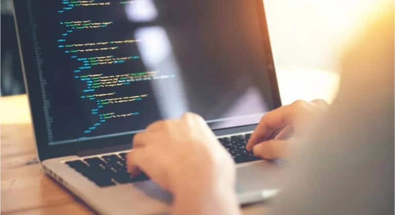 Programador trabalhando em código no laptop - Pós Graduação Engenharia de Software EAD, pós-graduação Java